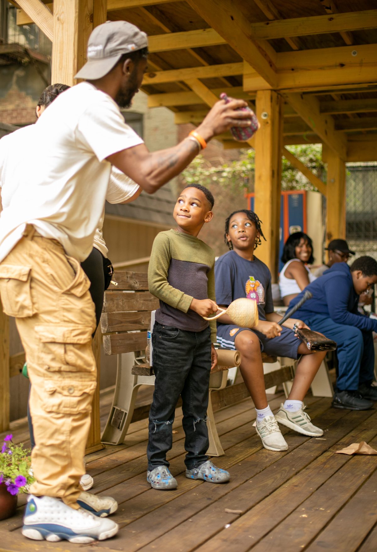An adult showing a small object to school age children.