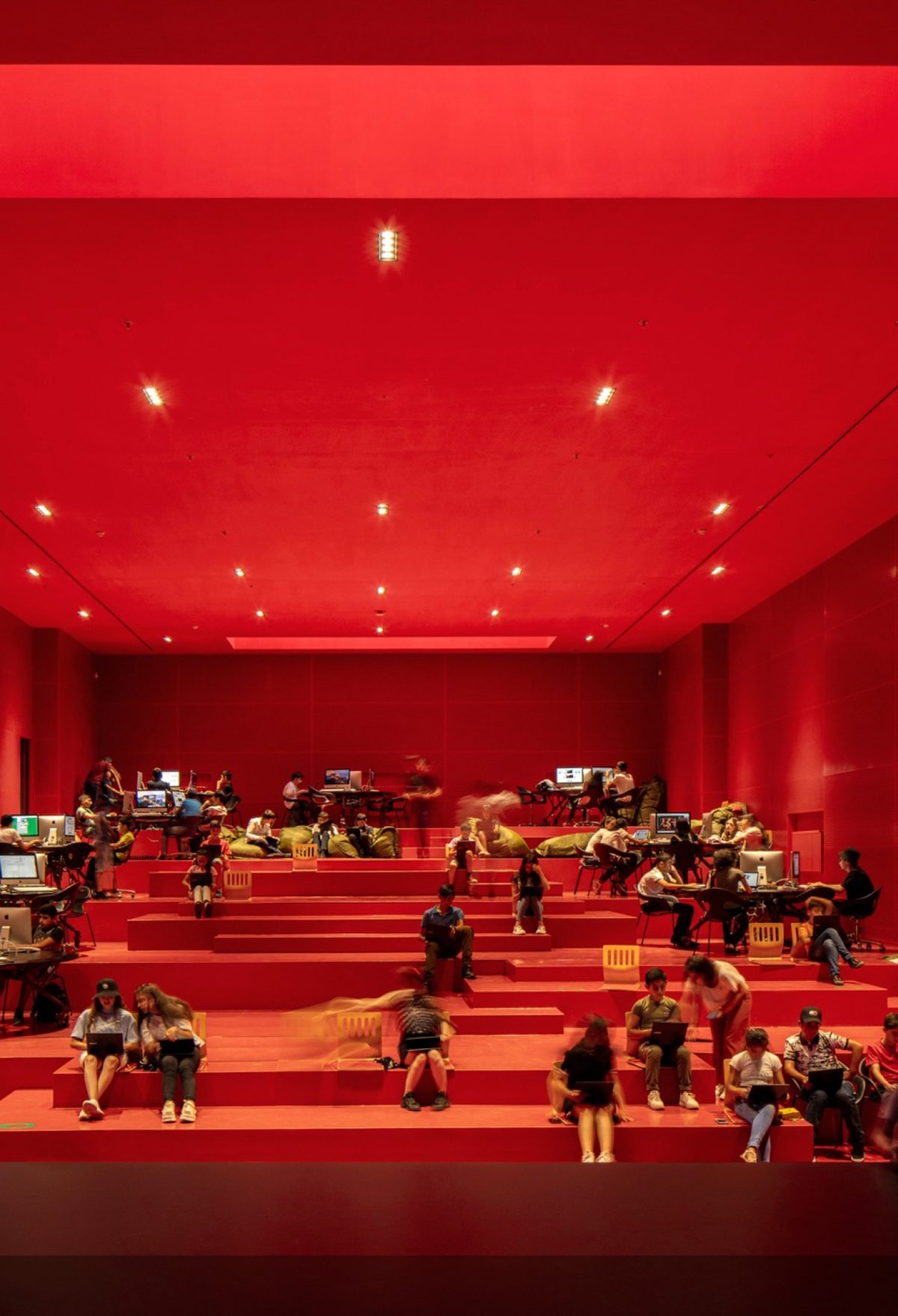 Students working in a bright red auditorium.