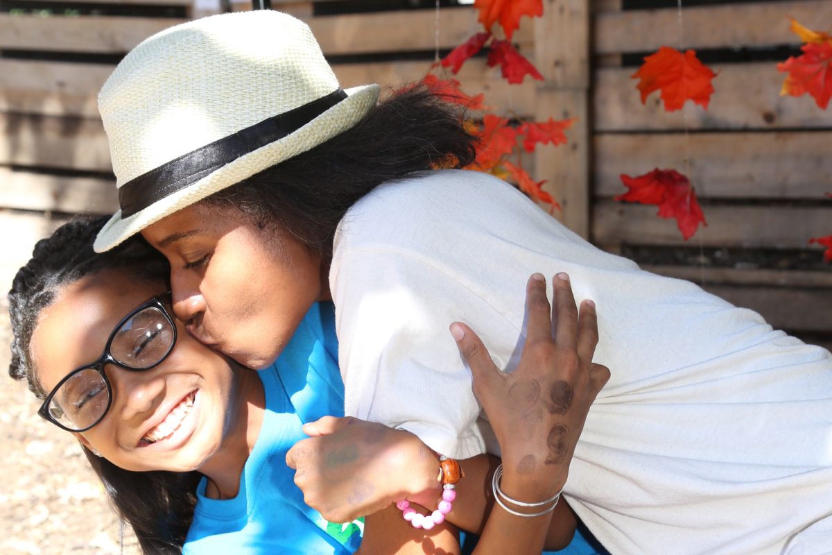 Image of woman leaning in to kiss her daughter